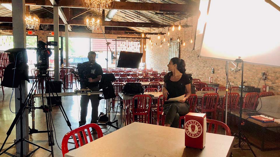 Two people talk on set at a brewery.