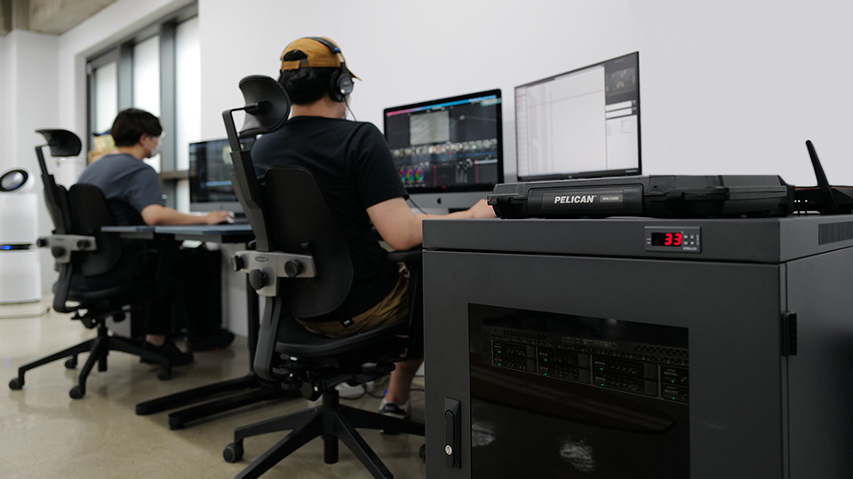 Two video editors working next to EVO video editing server