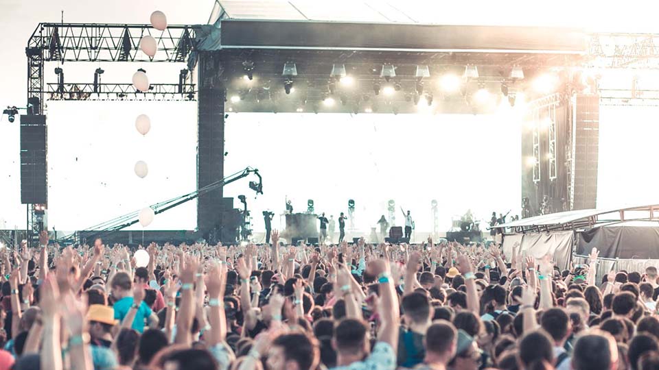 musician performing live on stage at concert in front of audience