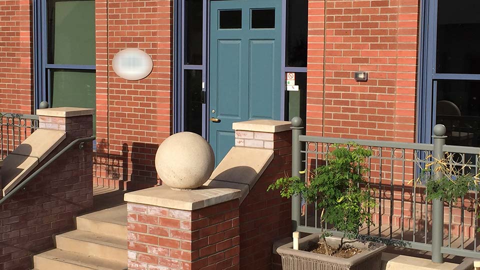 brick office building with blue door and stairs