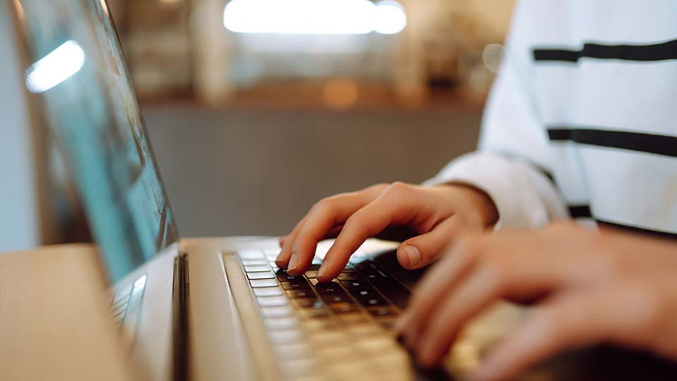 remote employee typing on computer working from home