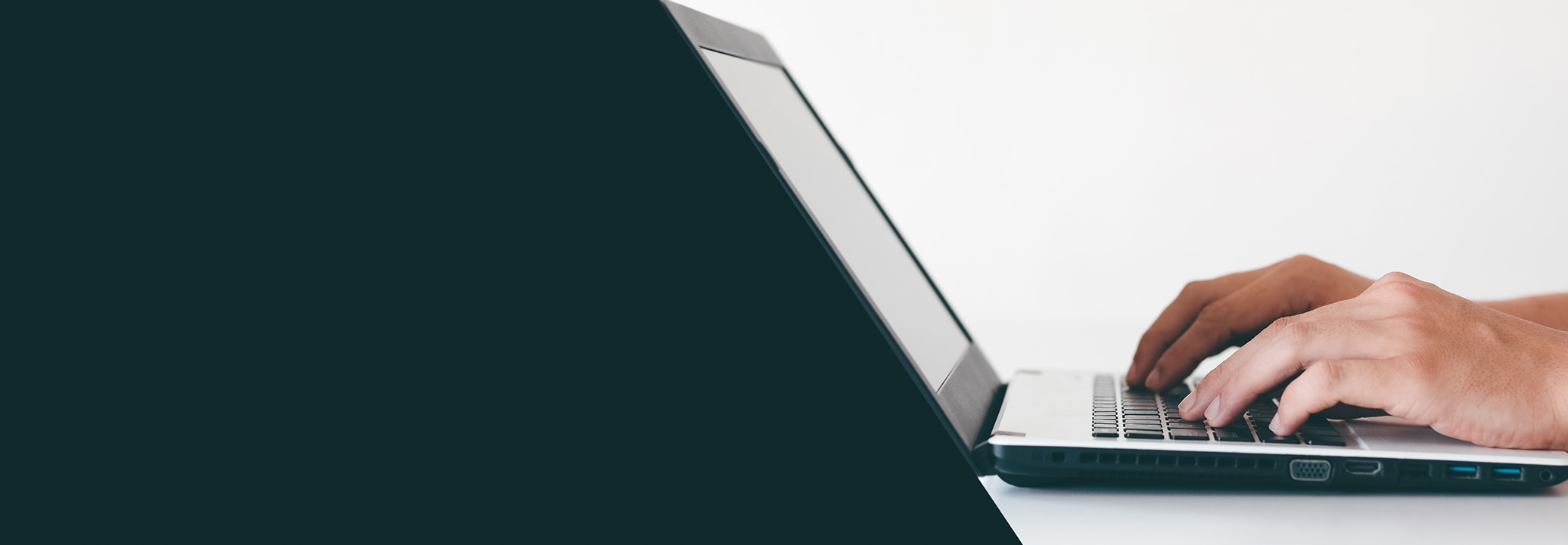 hands typing on laptop with slanted green background